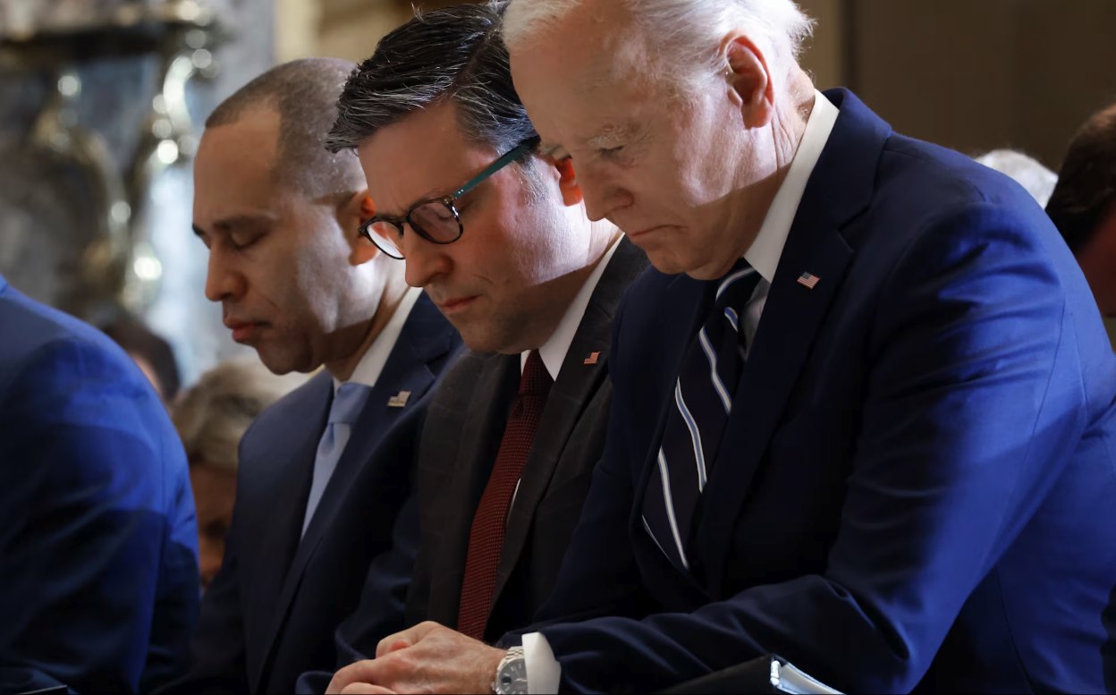 President Joe Biden with head bowed in prayer at the Prayer Breakfast