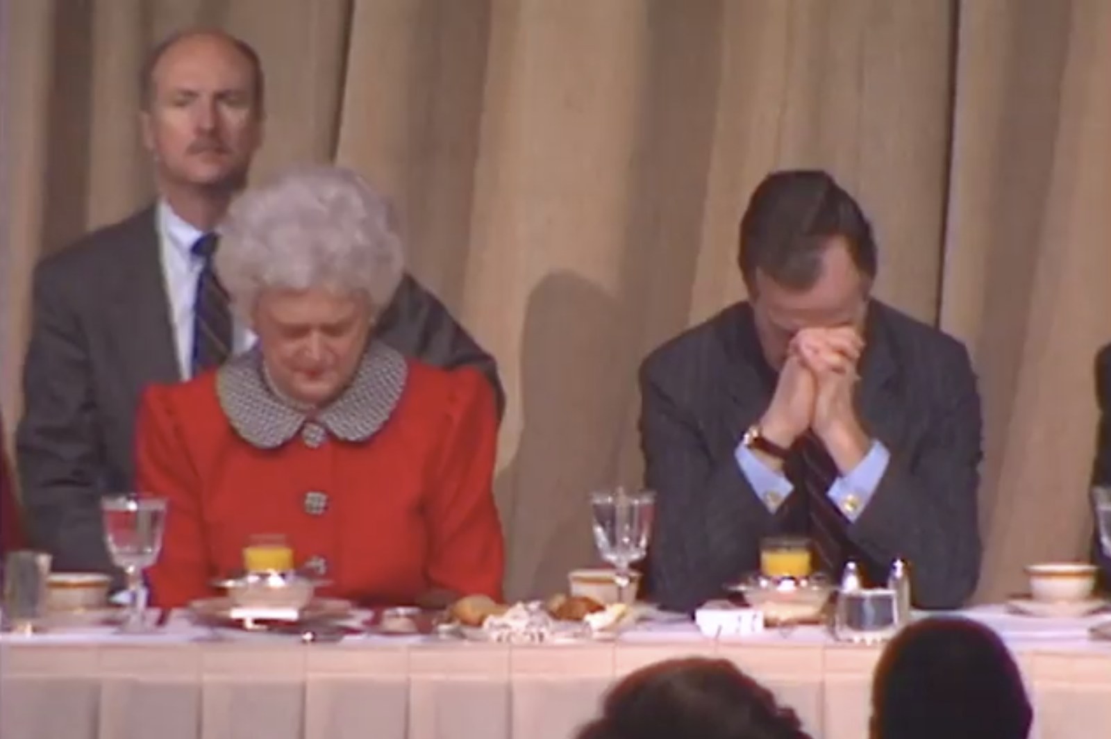 President George Bush and Mrs. Bush praying at the Prayer Breakfast